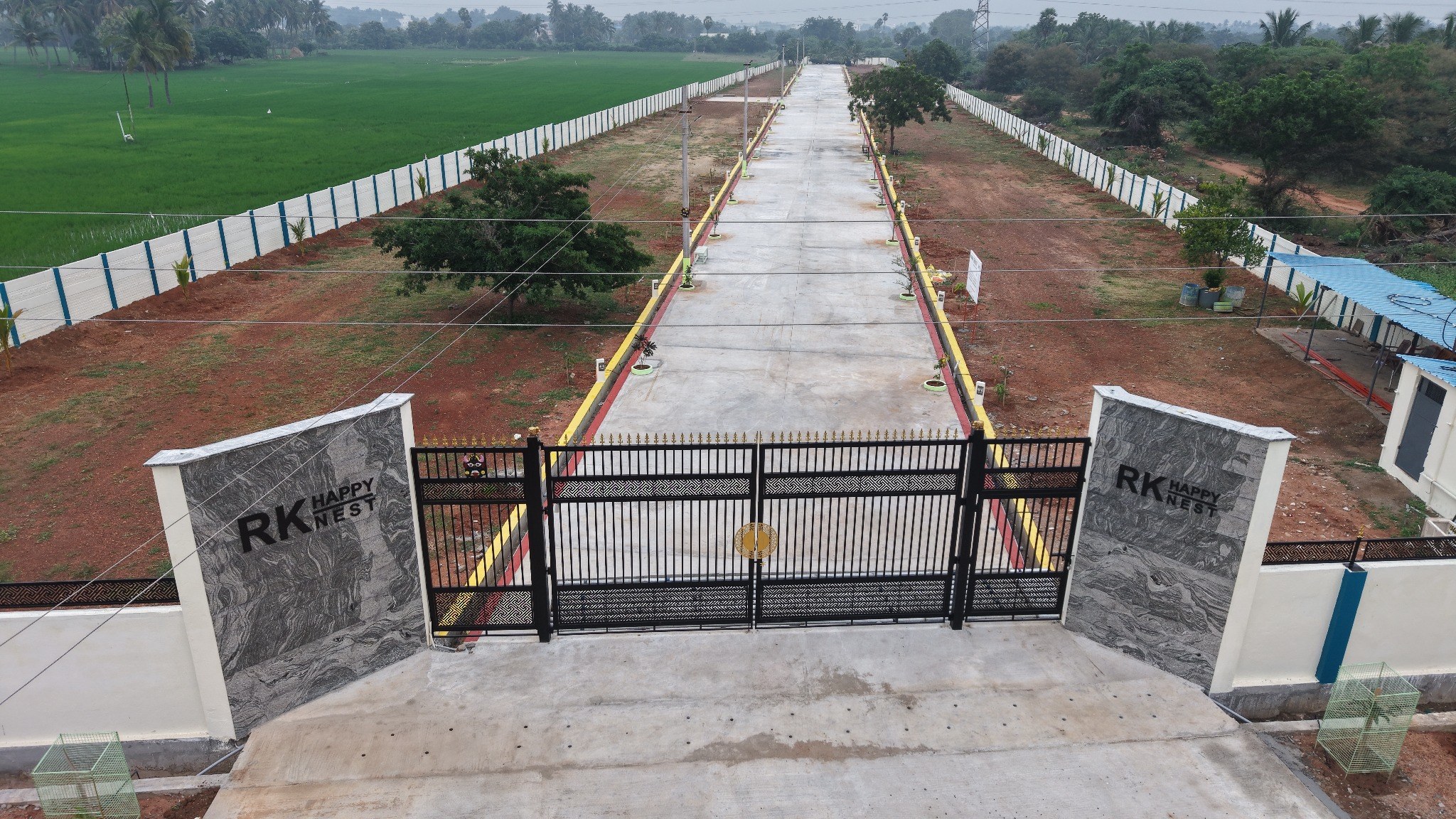 Clear view of the gated layout surrounded by greenery and open space
